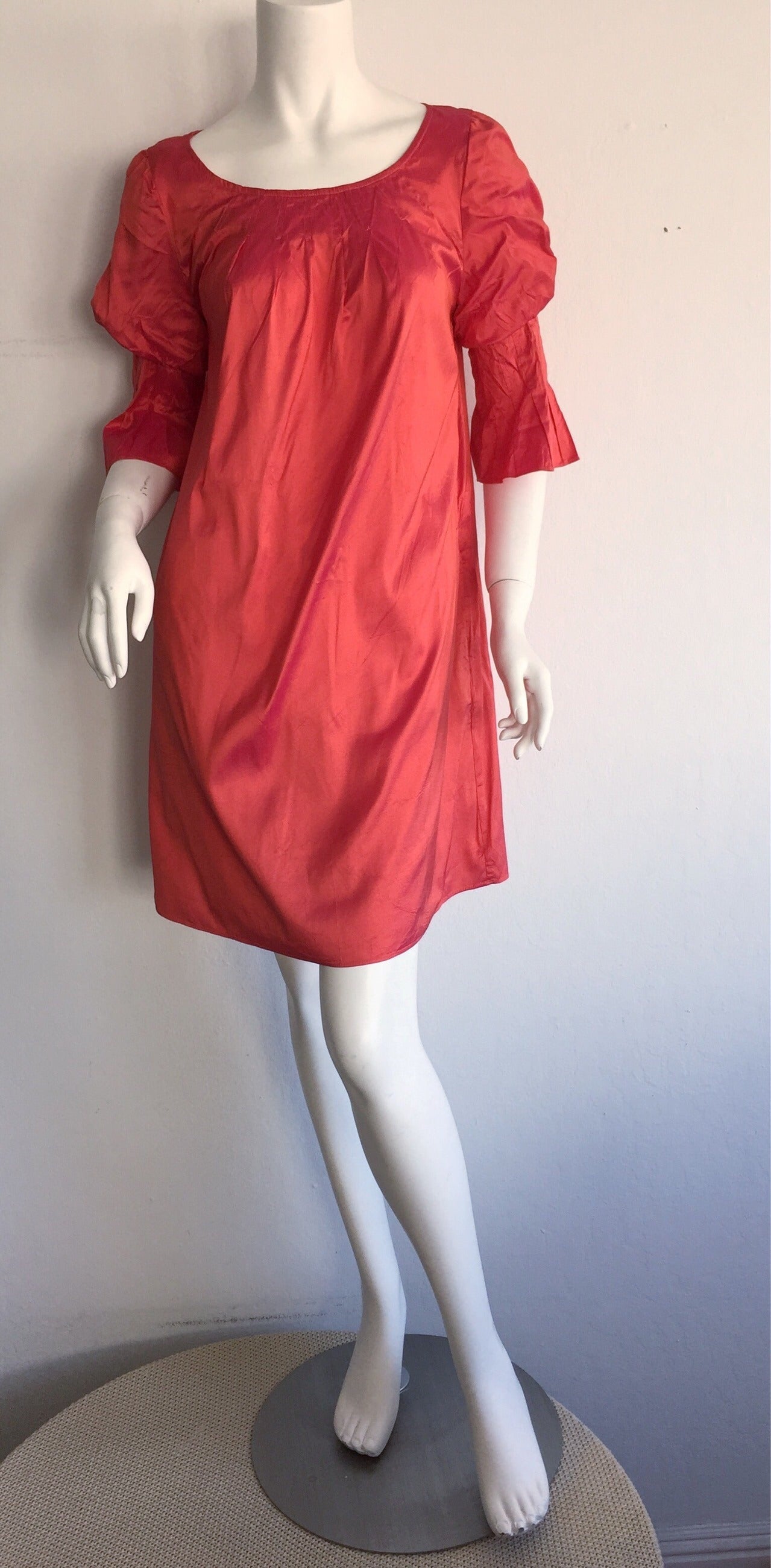 Pretty Nina Ricci iridescent silk dress! Hues of pink and salmon when looked at from different angles. Features two pockets at waist. Looks great belted, or alone. Very forgiving babydoll fit! Perfect with flats, sandals, wedges or heels! Flattering