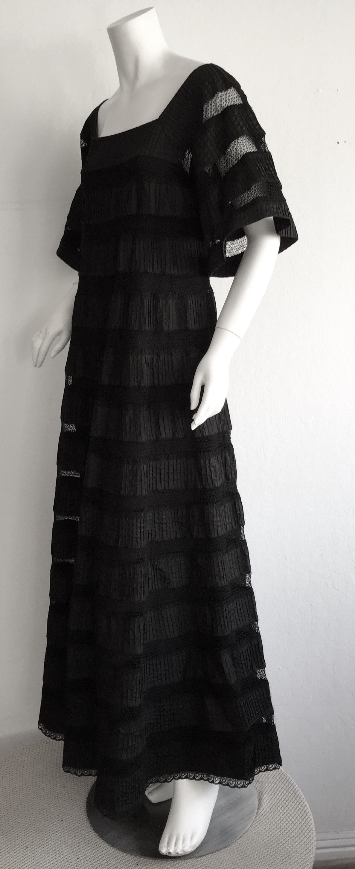 Gorgeous 1970s black cotton crochet/cut-out maxi dress, by Mexican designer, Tachi Castillo! Bell sleeves that hit just below elbow, with a full floor length. Lace edges, with crochet cut-outs throughout, with black cotton backing on body, and sheer
