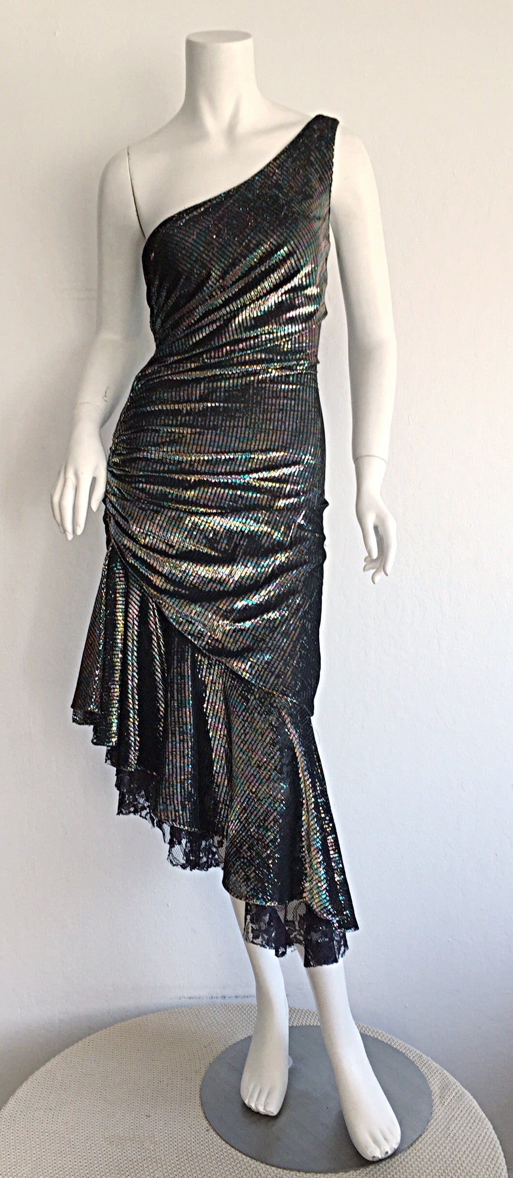 Wonderful late 70s disco STUDIO 54 vintage SAMIR one-shoulder dress! Colorful metallic, with ruched detail, that makes for a very flattering fit. Black lace drips from the hem for an incredible flared skirt. A perfect disco / cocktail dress that