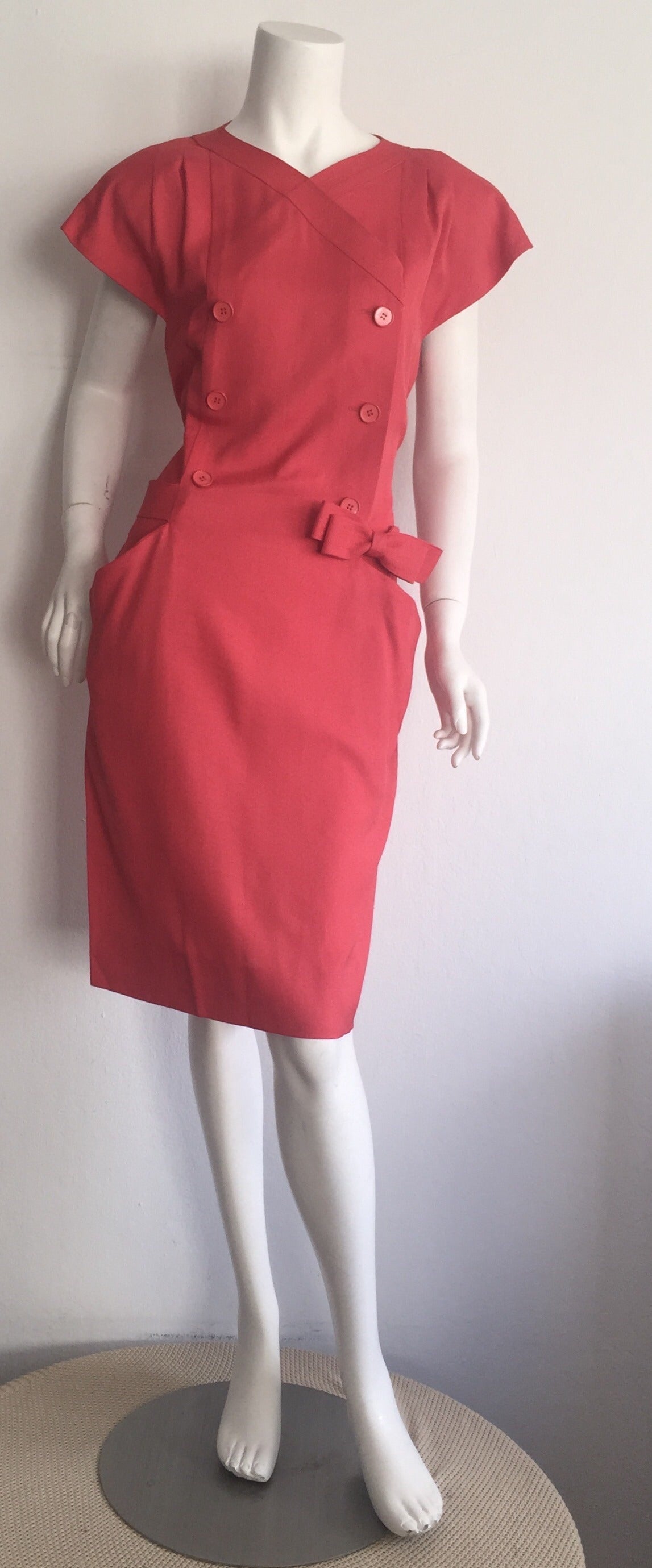 Such a pretty vintage Nina Ricci dress! Beautiful raspberry pink color, on a double breasted style! Attached bow belt wraps around the back, with hook-and-eye closure at front side. Pockets at both sides of the waist. Luxurious Cotton + Linen blend.