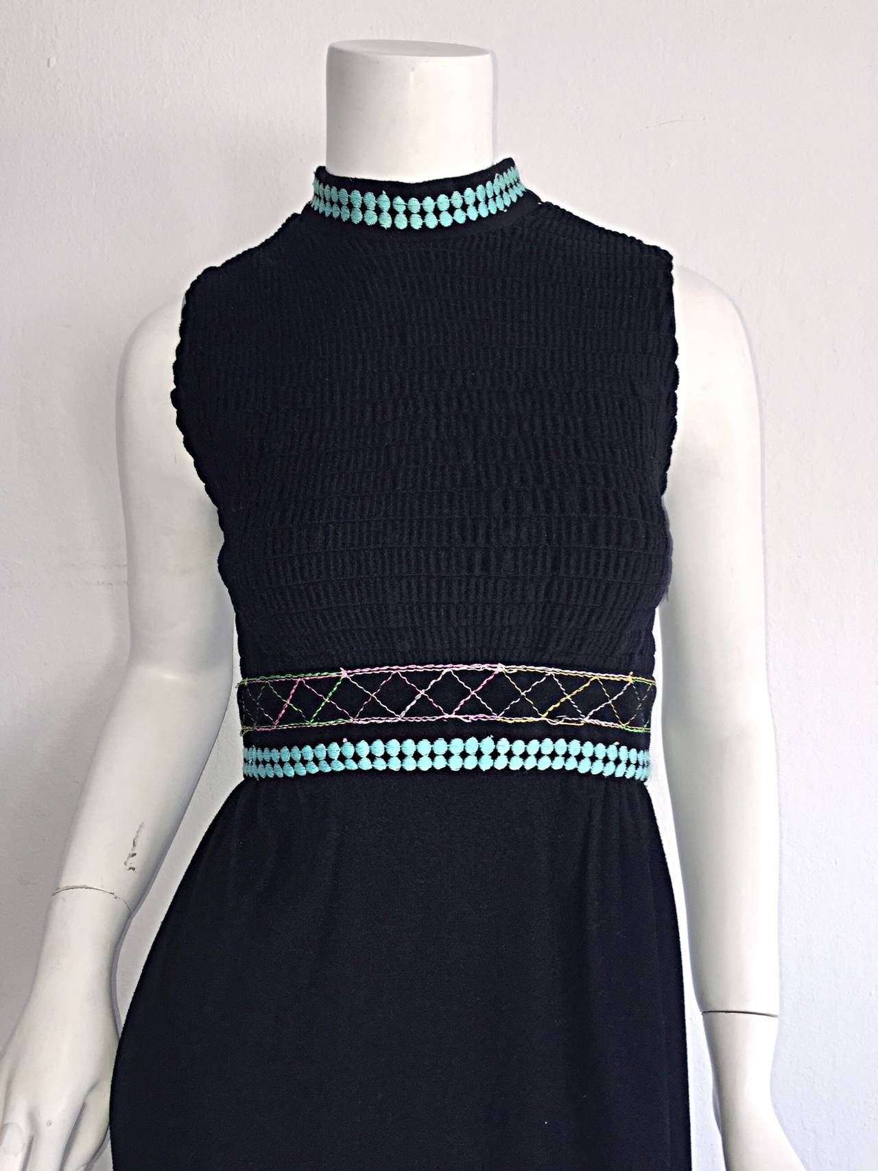 Magnifique robe longue noire Sandine Originals I. Magnin des années 1970 ! Tissage coloré à l'encolure, et surpiqûres colorées à l'ourlet. Parfait de jour comme de nuit. S'accorde parfaitement avec des sandales, des chaussures compensées ou des