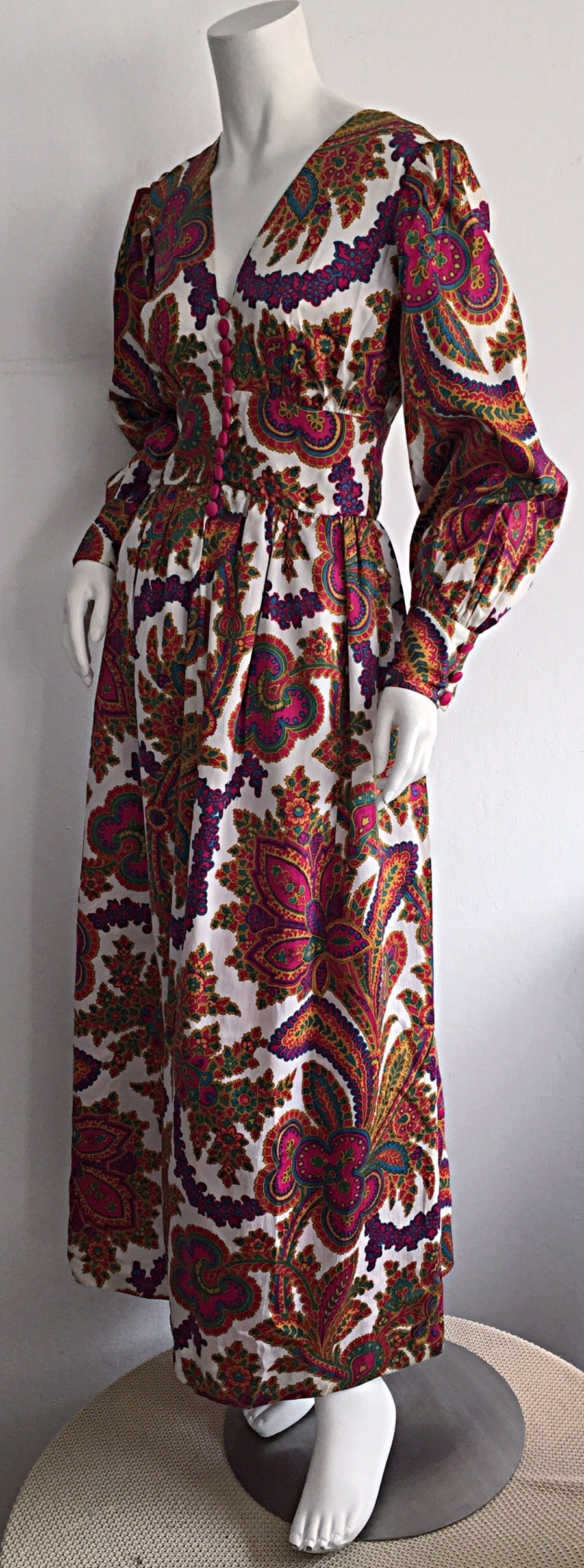 Wonderful 1970s vintage silk dress! Vibrant hues of pinks, purples, blues, greens, golds, and white on an awesome paisley print! Functional silk covered buttons up the bodice. Billow sleeves, with button closure at cuffs. Can easily transition from