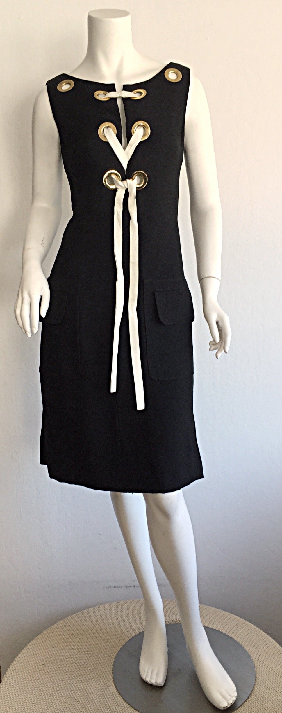 Super rare vintage 1960s PIERRE CARDIN black linen dress! From the coveted 'Space Age' era, this beauty features gold grommets, with original white vinyl ties up the front. Can be worn with ties in a bow, or let loose. Wonderful shift/sheath shape