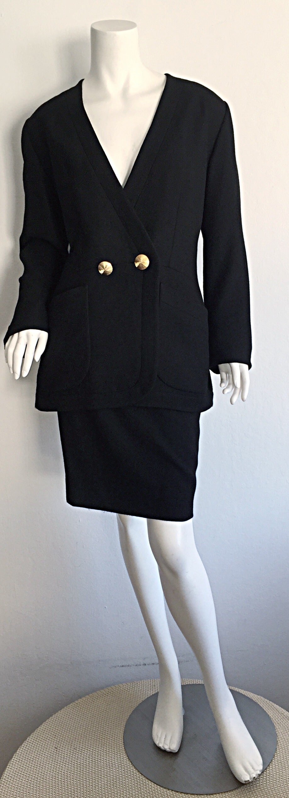 Magnifique tailleur jupe vintage Yves Saint Laurent 'Rive Gauche' noir ! Encolure flatteuse sur la veste, avec deux boutons dorés en dôme à la taille et aux poignets. Un bouton à l'intérieur de la taille permet également une fermeture
