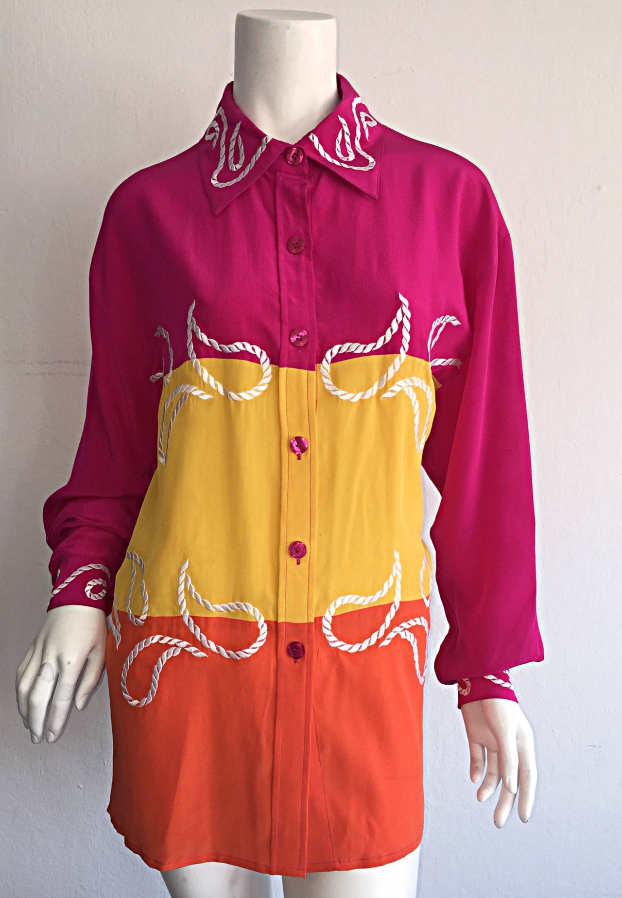 Awesome 1990s Diane Von Furstenberg silk blouse! Pink, yellow and orange color block, with white embroidered paisley on the body of the shirt, along with at the cuffs and collar. This vintage DVF number can be worn many ways. Looks great tucked into