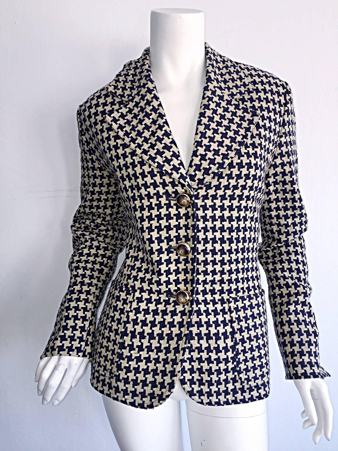 Chic vintage Christian Dior navy and ivory houndstooth blazer! Three gold and horn buttons up the front, with strap detail on back. Slit at cuff can be folded as a cuff for shorter arms. Pockets at both sides of waist. Looks great with jeans,