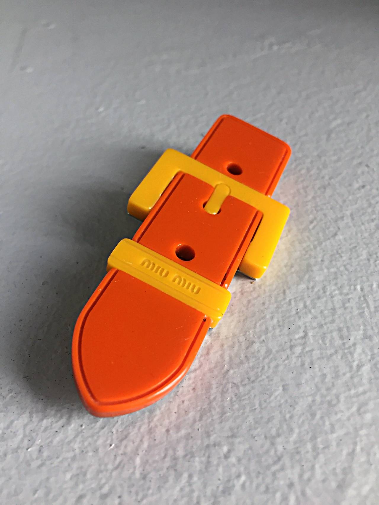 Awesome Miu Miu buckle brooch! Vibrant orange and yellow, this pin goes with everything! So many uses....perfect as a brooch on your favorite suit or sweater--Looks great used as the closure to a cardigan/jacket. Also, a great accessory for any bag!