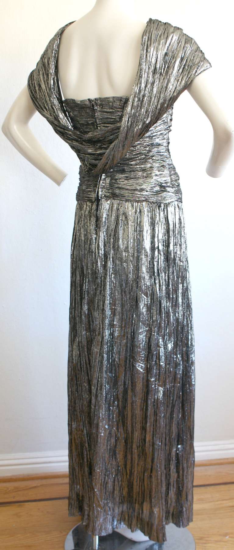 Gorgeous vintage Ted Lapidus Haute Couture cut-out gown in metallic silver. Features sexy cut-outs at bust, with draping in the back. Avant Garde style, with acordian-like pleating. Perfect for any fancy occasion (great for the holidays)! In great