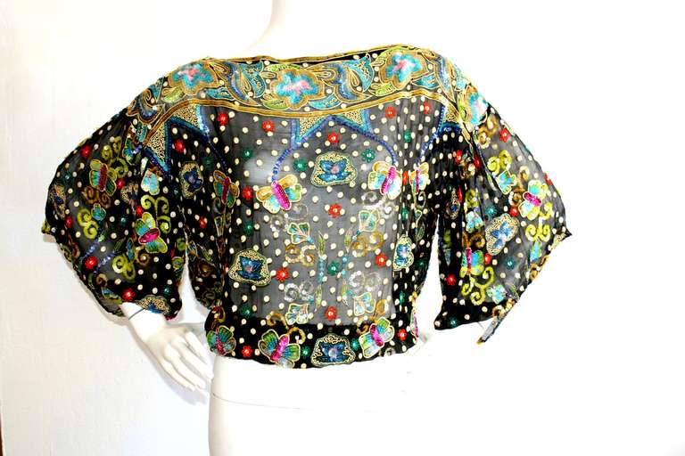 Incredible 1970s Vintage Geoffrey Beene sequin butterfly blouse. Features drawstring waist to accommodate many sizes. Silk chiffon background, with bell sleeves. In great condition. Will fit Size Small-Large, due to drawstring waist.