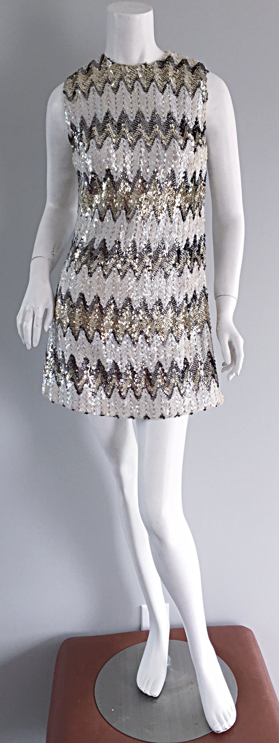 Beautiful vintage 1960s A-Line sequin mini dress! Features zig zags of sequins in silver, white and gold!! Flattering A-Line fit that looks great paired with sandals, wedges or strappy heels. Metal zipper up the back. Fully lined. In great