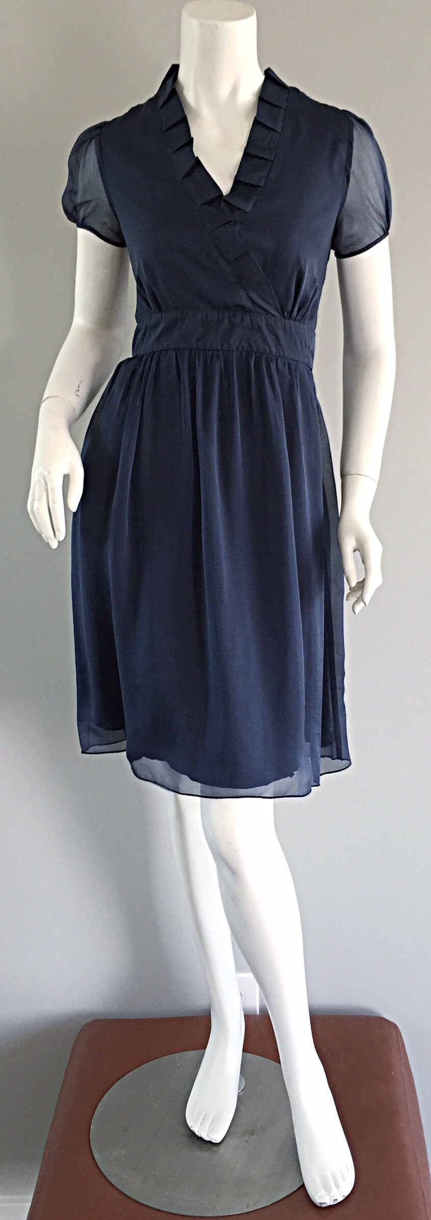 Beautiful Chloe, by KARL LAGERFELD 1990s dress! Luxurious layers of navy blue silk. Pleating details at collar. Chic semi-sheer puff sleeves. Hidden zipper up the side with hook-and-eye closure. 
Such a flattering and flirty dress! Perfect for day