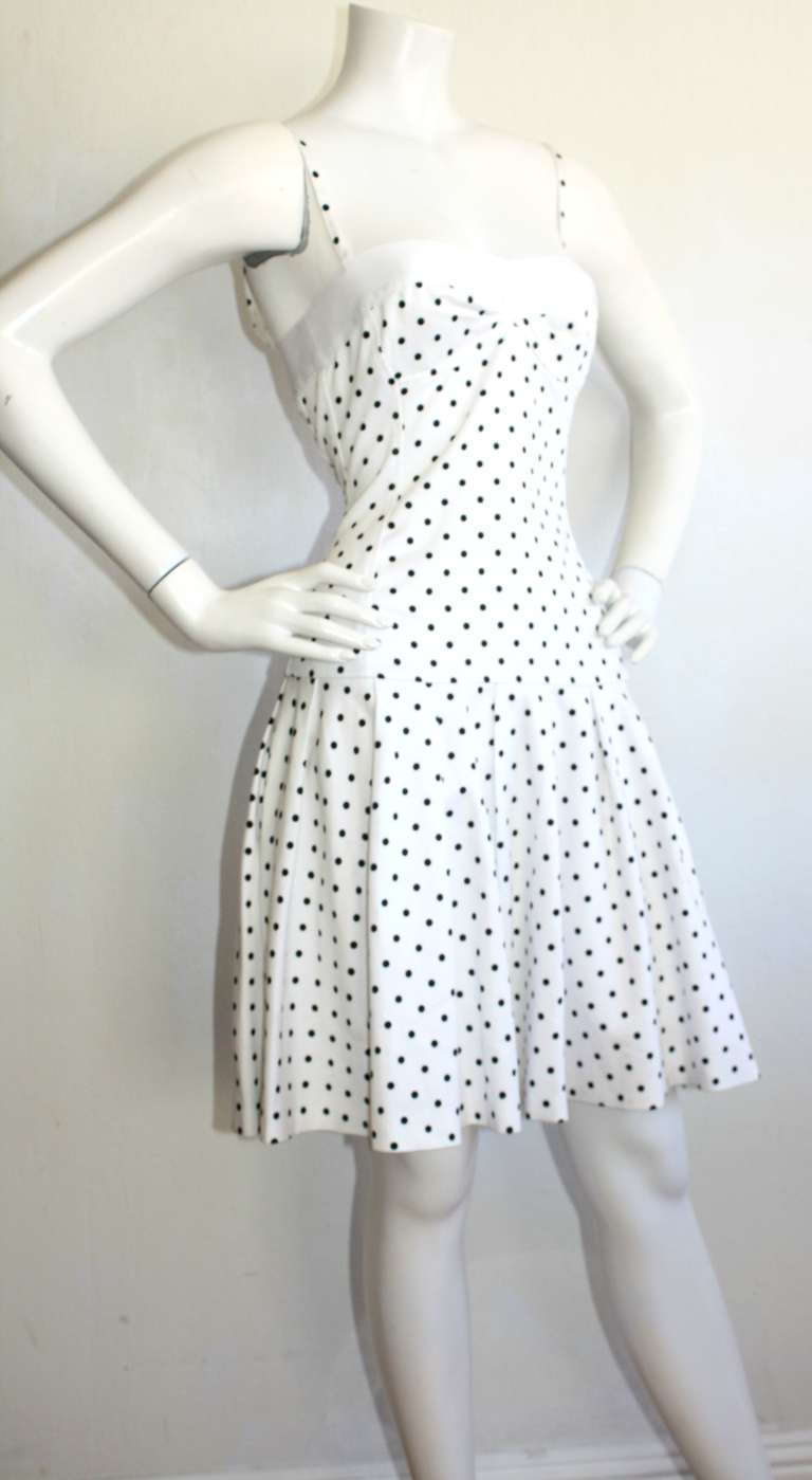 Such a CHIC Vintage 1990s Enrico Coveri white and black polka dot cotton dress! Silk ribbon trim at bust, with full skirt. "Pretty Woman" style, that zips up the back. Approximately Size Small-Medium (has stretch)

Measurements:
36-40