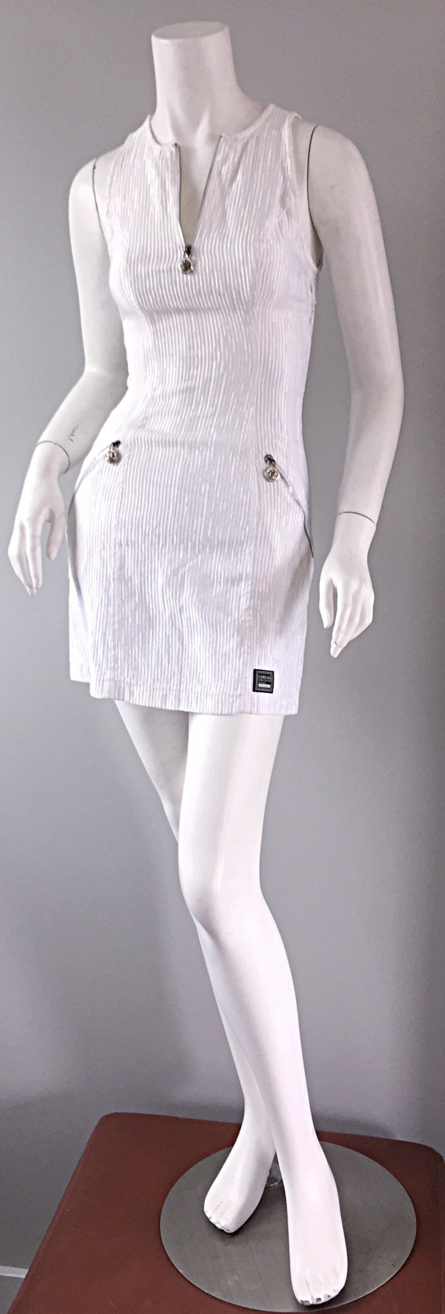 The ultimate vintage Gianni Versace pre-death bodycon dress! Stark white color, featuring Medusa zippers, encrusted with rhinestones. Ribbed detail, with a 'scuba' fit. Extremely flattering, with the option to wear the dress zipped up, or left open.