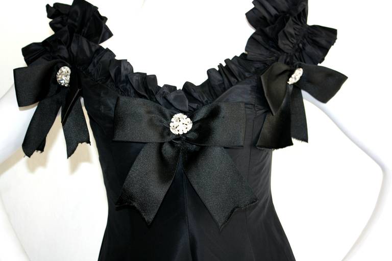 A truly gorgeous vintage gown by the great Oscar de la Renta! Features off-shoulder sleeves, accented with beautiful origami ruffles. Three silk bows surround the bust, each adorned with a significant rhinestone pendant. Incredible full skirt, with