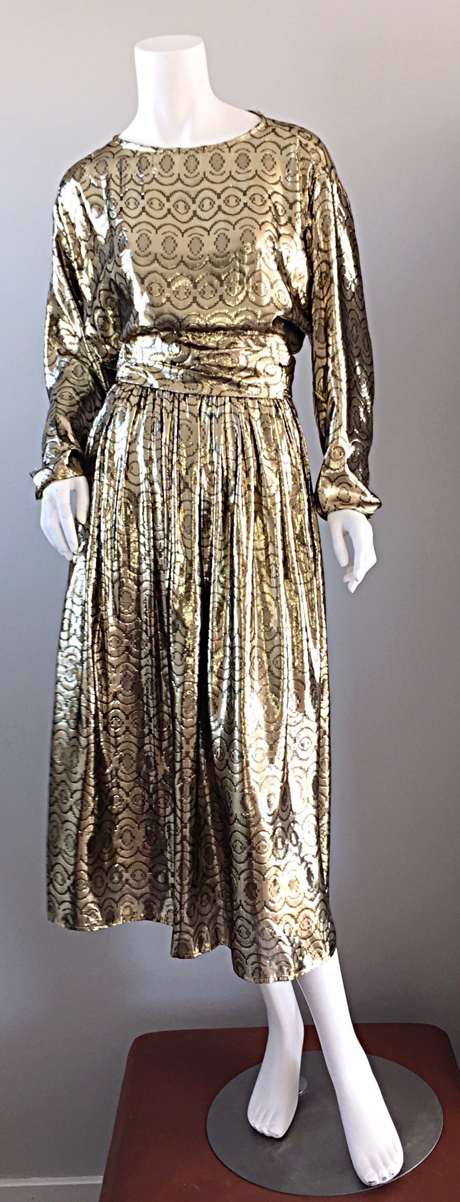 Incredible vintage 'LIQUID GOLD' disco dress! Chic dolman sleeves, with a detachable belt in same fabric, with two rhinestone closures at back. Faint swirl prints throughout. Full skirt that looks great on the dance floor! A real statement dress,