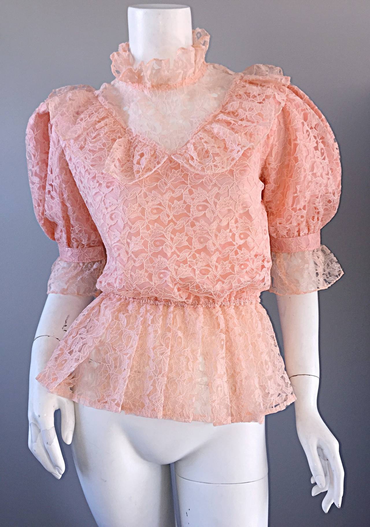 Cute 1970s 'Victorian Revival' pale pink lace blouse! High lace neck, with pearl buttons at back neck. Stylish 'puff sleeves.' Peplum hem, with an elastic waistband. Hook-and-eye at each sleeve cuff. Made extremely well, and very versatile. Looks