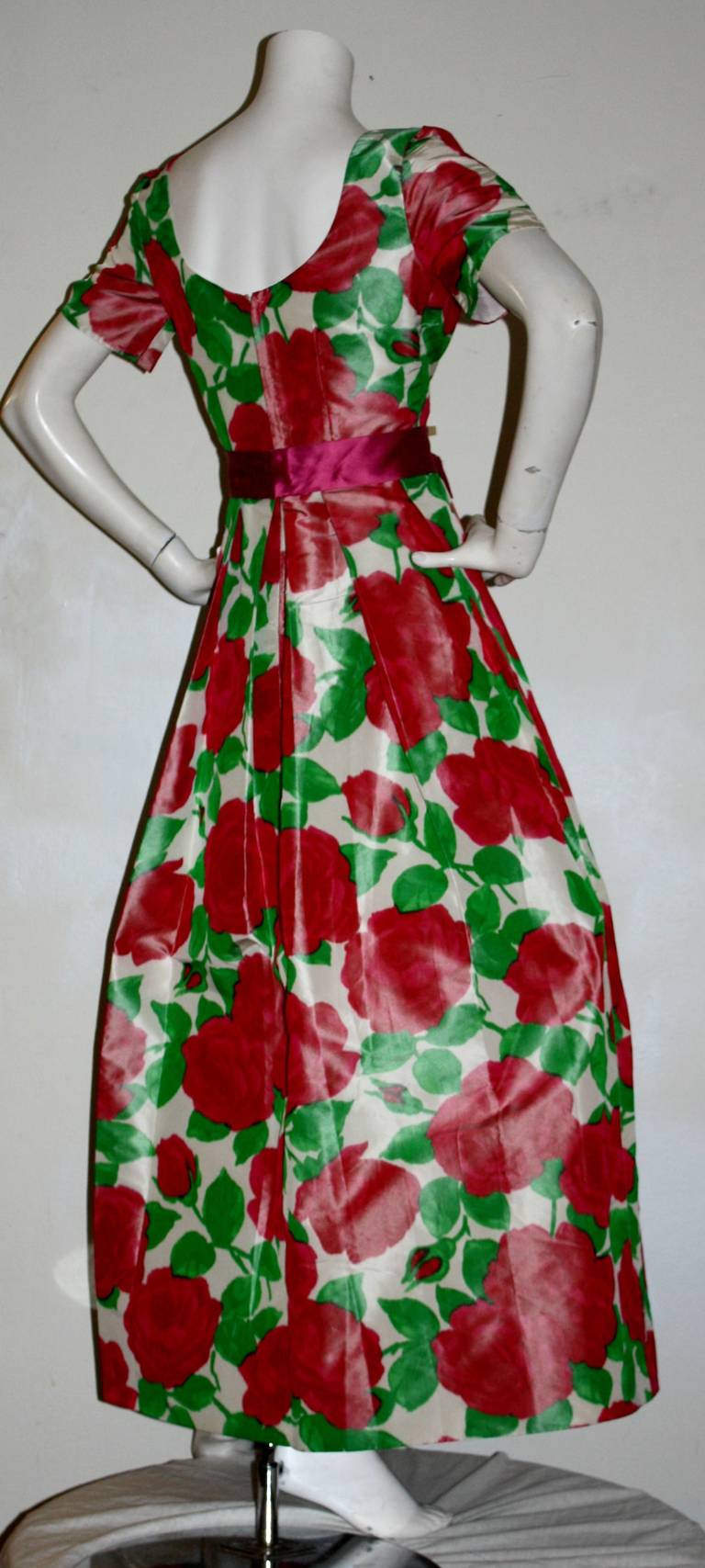 Stunning vintage Richilene for Elizabeth Arden silk taffeta gown, featuring all-over hot pink floral print, mixed with green foliage. Features matching attached silk velvet bow belt that snaps in back. Flattering scoop neckline. Would also look