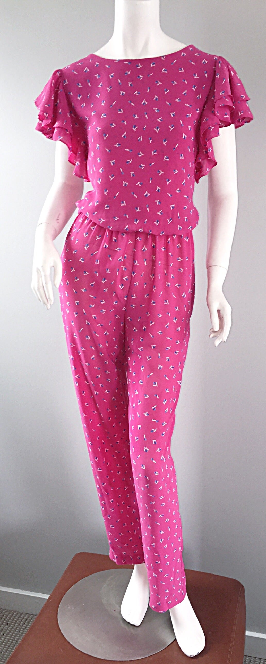 Insanely CHIC vintage jumpsuit! Perfect pink color, with tiny flower print throughout. Incredible ruffled sleeves, that look amazing on! Wonderful slim trousers, with an elastic waist. Peek-a-boo back. Easily transitions from day to night. Great