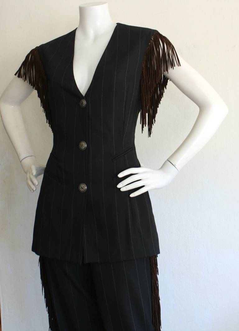 Is there any wonder why Rifat Ozbek has been named "Designer of the Year" twice in career?!?! This fabulous vintage Rifat Ozbek pinstripe suit consists of chic high-waisted trousers, and a marvelous matching vest! Leather fringe outlines