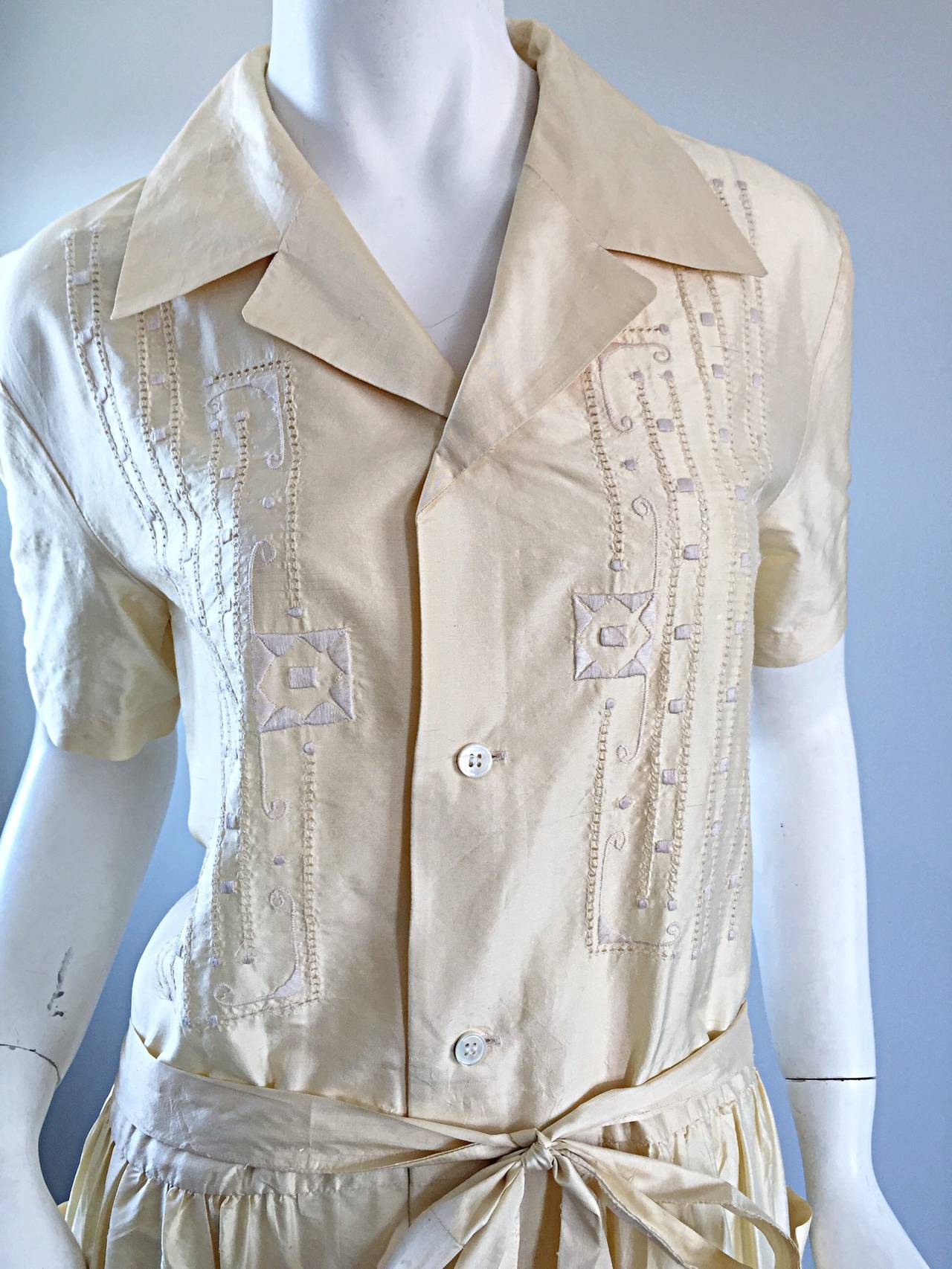 Important and chic vintage early 80s Comme des Garcons musuem worthy Mexican ivory silk shirt dress! Exaggerated collar, with intricate embroidery detail at bust. Pockets at both sides of the full skirt. So much detail with insane intricate design!