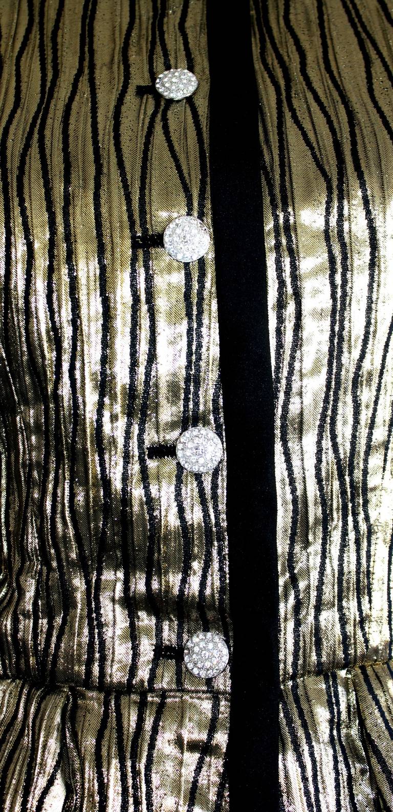A truly stunning piece of fashion history! Vintage YSL Rive Gauche gold metallic peplum jacket. Features intricate detail of black 'swirled' vertical pinstripes throughout, and rhinestone encrusted buttons. Fully lined. In great condition. Marked