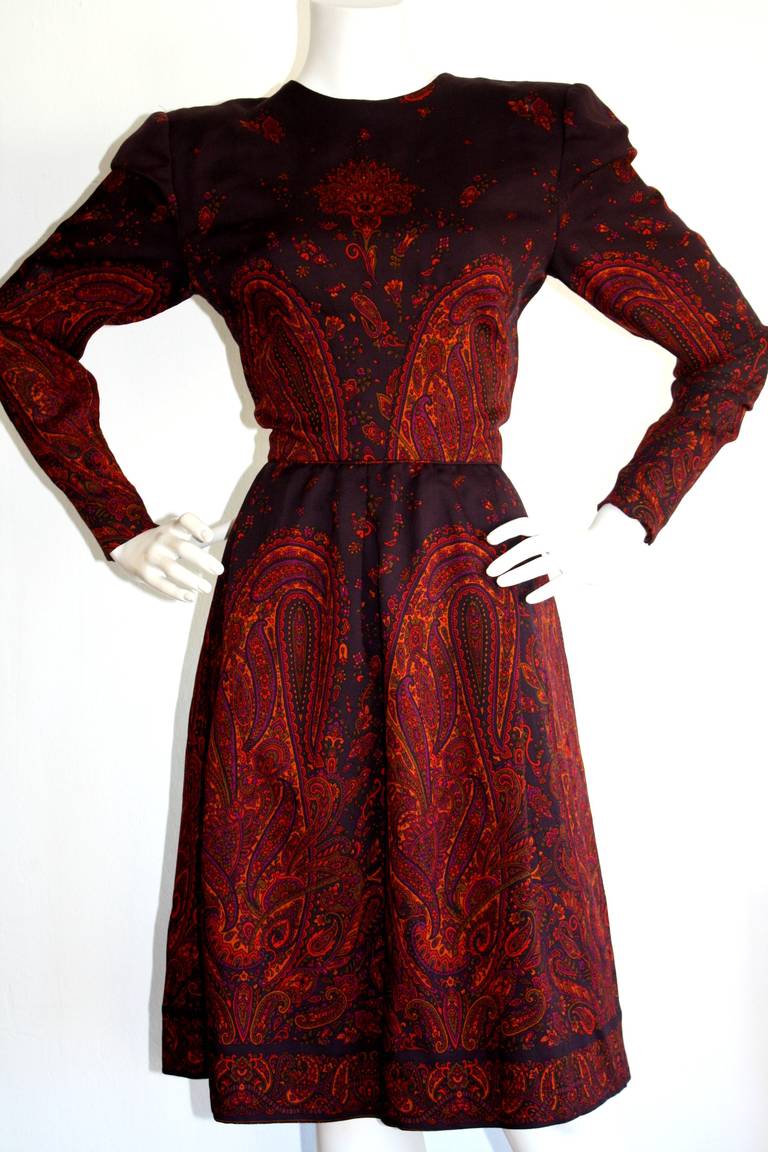 Gorgeous hand-finished vintage numbered Pauline Trigere long sleeve dress. Beautiful eggplant purple, with a vivid paisley print throughout. Features zips at sleeves. Fully lined. In great condition. Approximately Size Small

Measurements:
38