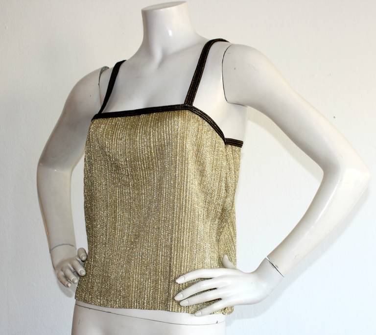 Incredible early vintage YSL gold metallic Babydoll blouse! Black sleeve straps adorned with intricate gold design. Amazing pleated detail makes for a very flattering fit! In great condition. Approximately Size Small

Measurements:
34 inch