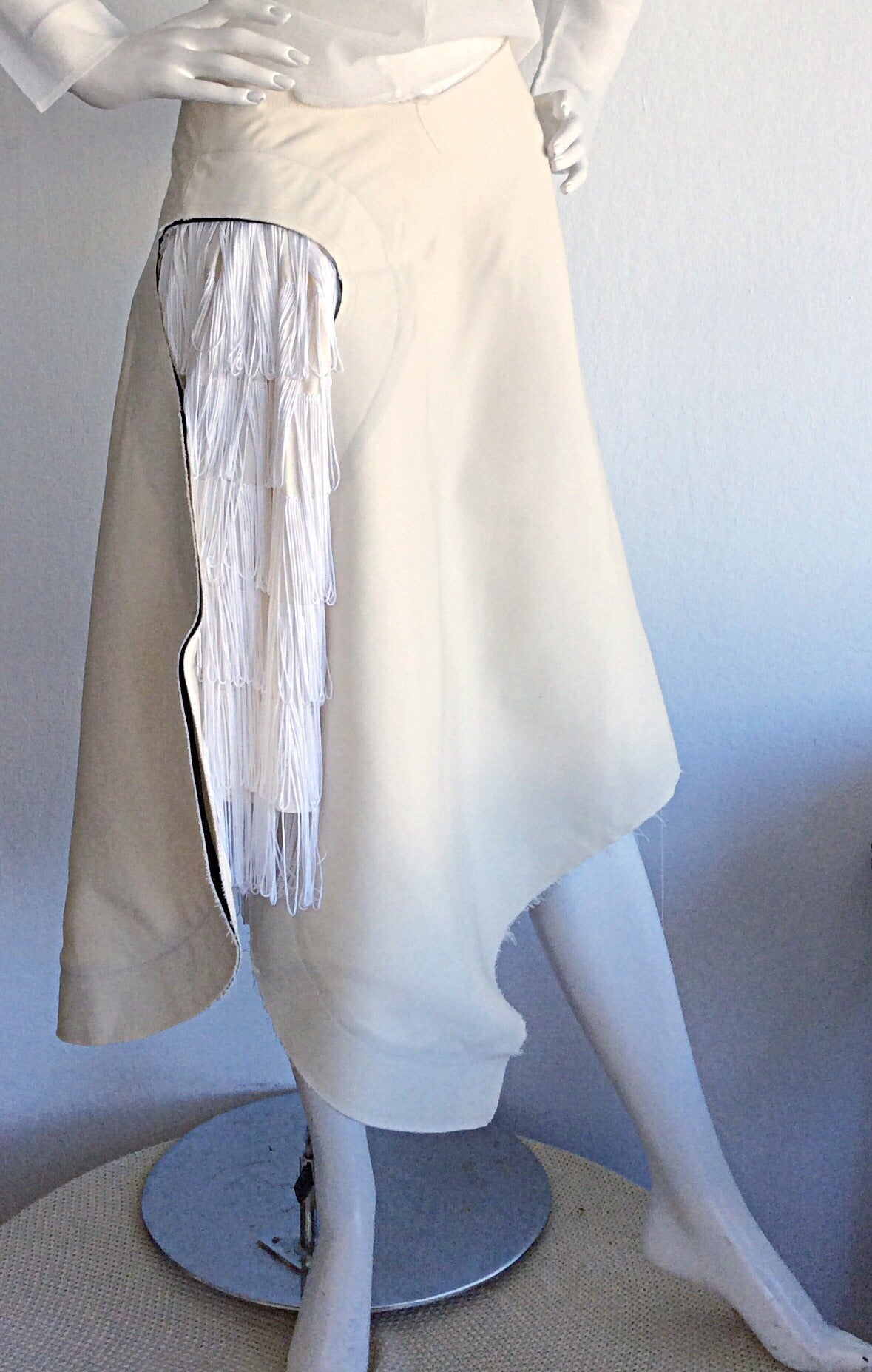 Incredibly RARE Comme des Garçons white Top & skirt. Top is semi-sheer, with two opaque appliqués at the breasts. Asymmetrical skirt, with peek-a-boo fringe at side. From the 