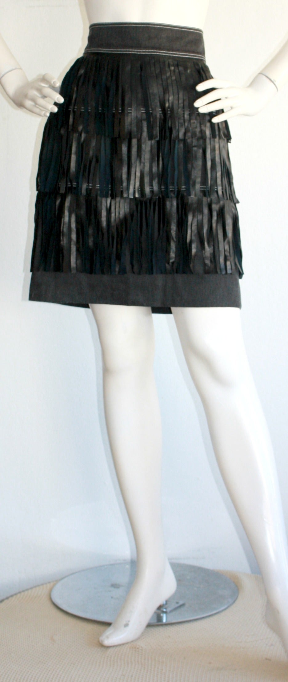 Incredible, and rare, vintage Patrick Kelly denim skirt, with tiers of black leather fringe! Charcoal colored denim. Looks great when walking, or on the dance floor! Easy to transition from day to night. Made in France. In great condition. Marked