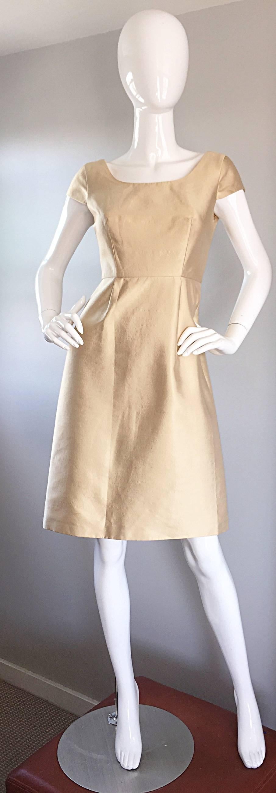 Magnifique robe en soie BADGLEY MISCHKA de couleur or clair, style années 50 ! Une couleur dorée parfaite, sur la soie la plus fine ! Style ajusté et évasé, avec une légère ligne en A. Manches courtes et dos échancré. Une coupe si flatteuse, qui