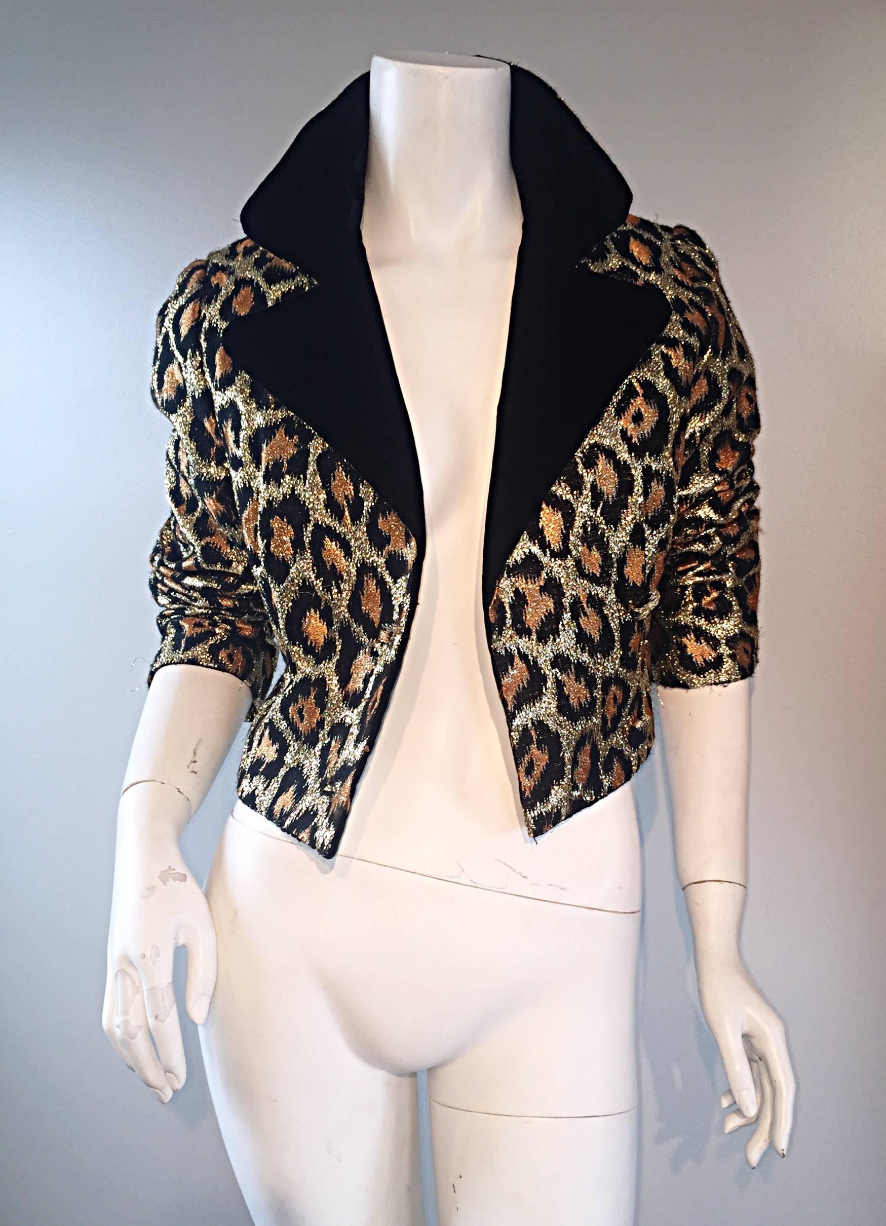 Incredible early 1960s double breasted cropped metallic leopard jacket! Features a chic animal print in gold, bronze, and black. Black velvet lapels and collar. Fully lined. Leopard print is always in style, and this is the perfect amount to 'jazz'