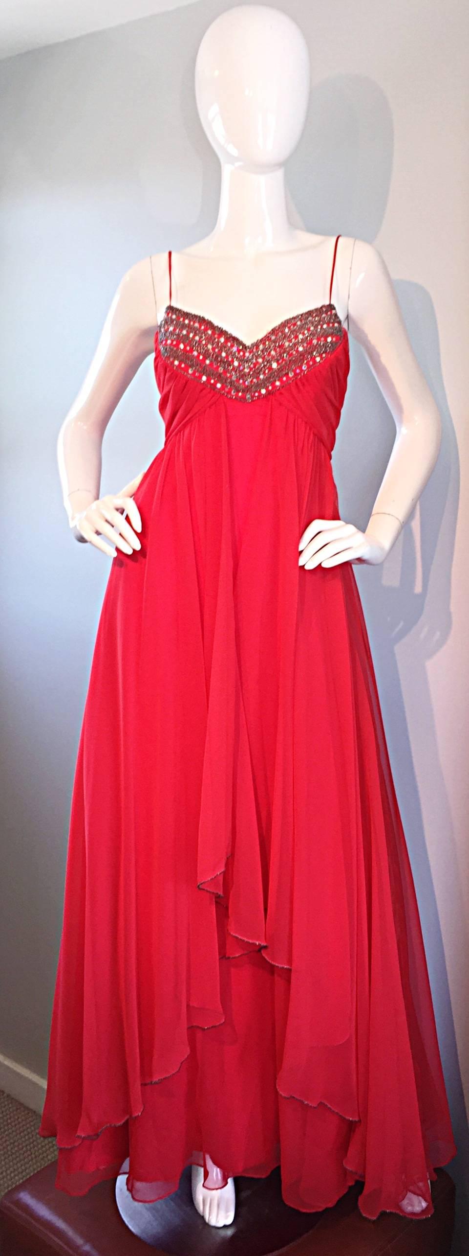 ¡Excepcional vestido de gasa rojo carmín de los años 70 de MIKE BENET! Estilo diosa griega, con capas asimétricas de gasa roja por toda la prenda. Movimiento asombroso, con gran atención al detalle. Favorecedor corpiño en V fruncido, ¡incrustado con