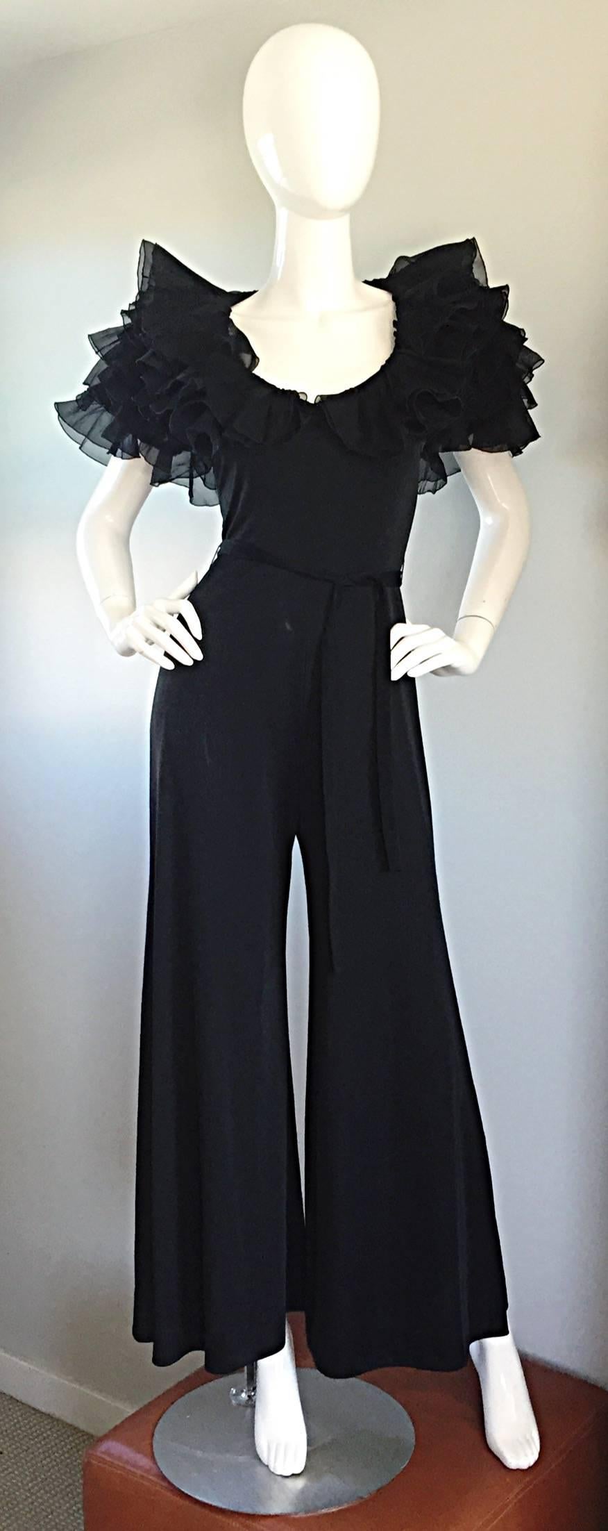 Exquisite late 70s / 1970s MIGNON black jersey jumpsuit! Features a figure flattering stretch to fit silk jersey material, with black silk chiffon tiered ruffle sleeves. Hidden zipper up the back, with hook-and-eye closure. Avant Garde flare, with