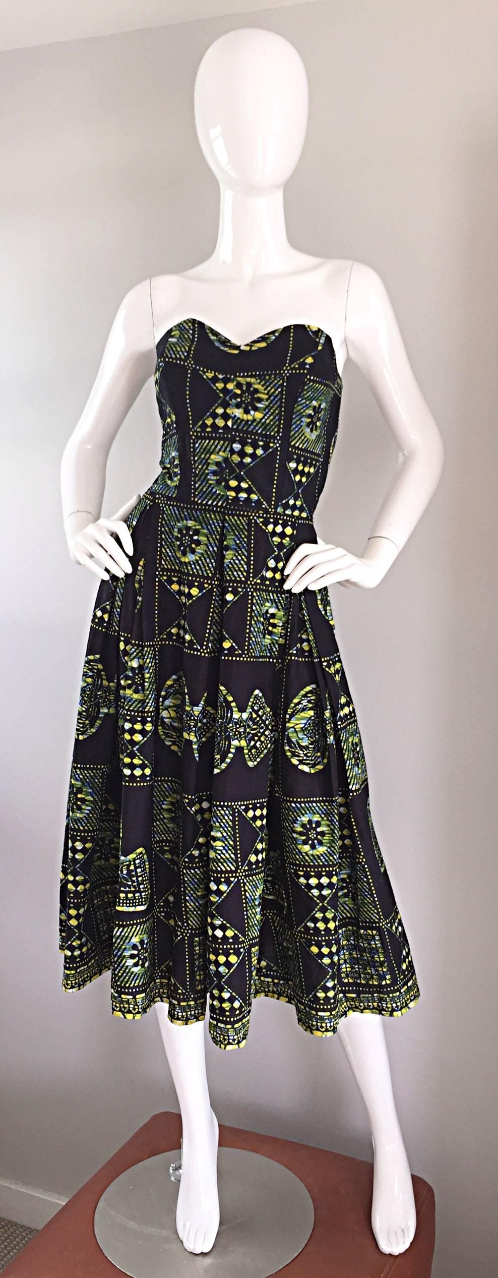 Bombshell vintage 50s strapless Hawaiian dress! Features an allover navy blue and yellow tribal print. Cotton fabric, with a boned bodice, and full skirt, which could easily accommodate a crinoline for an even fuller skirt. Full metal zipper up the