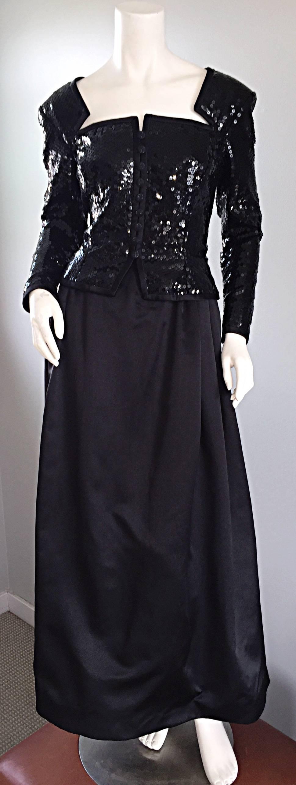 Gorgeous vintage TRAVILLA black gown! Features an all-over sequined bodice, with avant Garde cut-outs, trimmed in black satin at the bust. Looks like a strapless dress with gloves. Mock jeweled buttons up the bodice, with a nipped wasp waist. Full