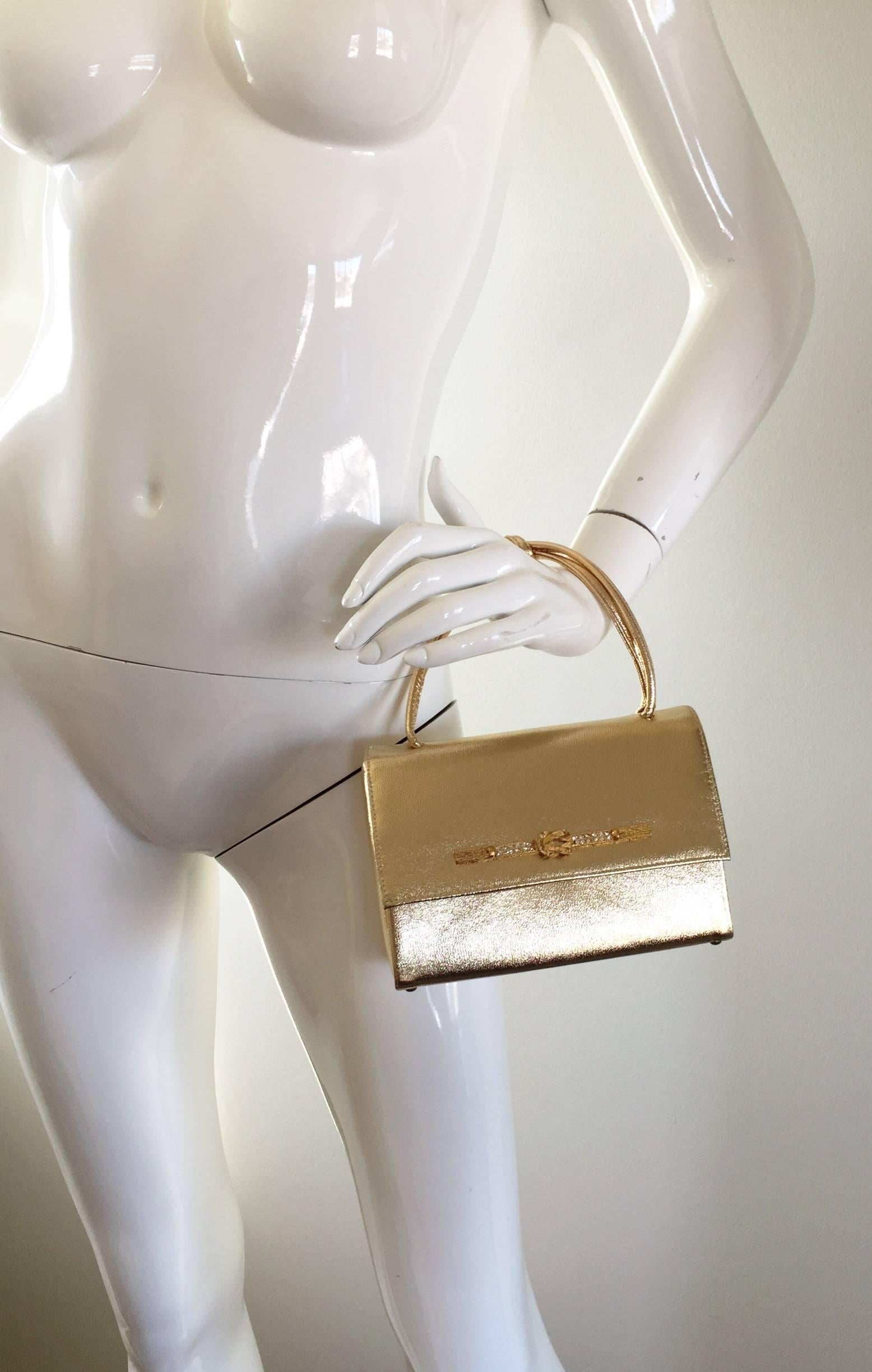 Exquisite 1950s vintage gold leather metallic handbag, with matching gloves! Extraordinary construction, with heavy attention to detail. Features a knotted handle and a gold bar across the front, encrusted with rhinestones. Four feet on the bottom
