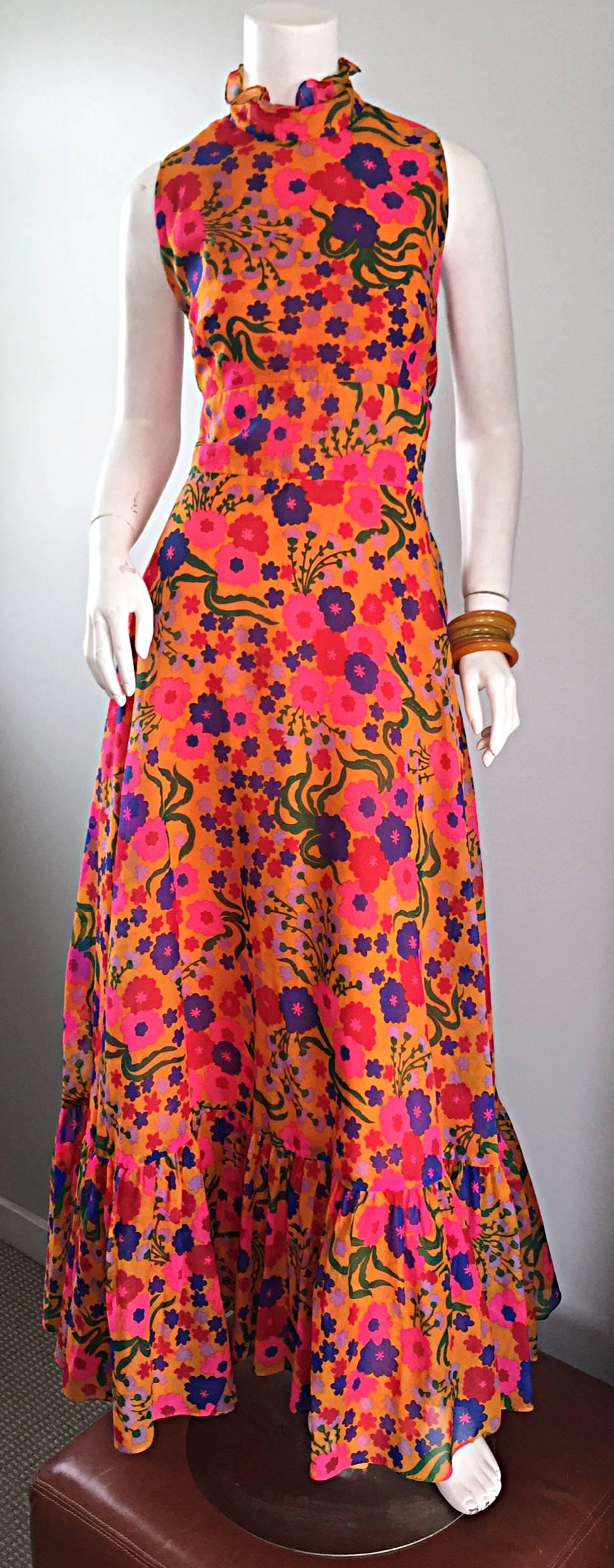 Amazing 70s colorful psychedelic chiffon maxi dress! Features a vibrant floral print in orange, pink, blue, green, red and purple! Chic ruffled neck, and ruffle hem. Peek-a-boo back with buttons at top back neck. Full metal zipper up the back.