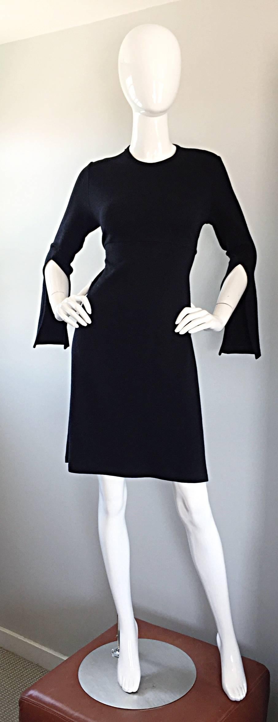 The perfect little black dress by MORGANE LE FAY, but with an awesome twist! Features 'slashed' sleeves for a slight Avant Garde look! Expertly constructed with a heavy eye to detail and construction. Wonderful tailored fit with an attached tie belt