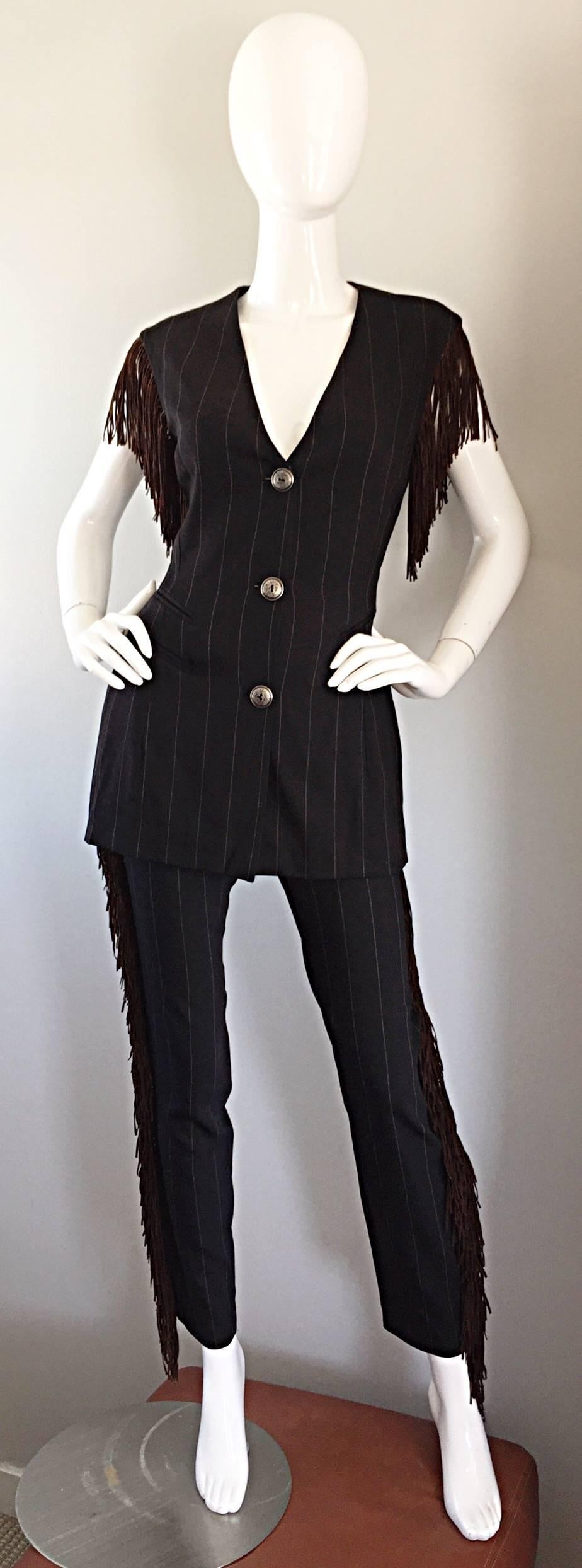 Incredible, and oh so rare vintage RIFAT OZBEK black and white pinstripe tailored pant suit, with brown suede fringe! Waistcoat is fitted, and features three silver buttons down the bodice. Brown suede fringe at each arm. Trousers are high waisted