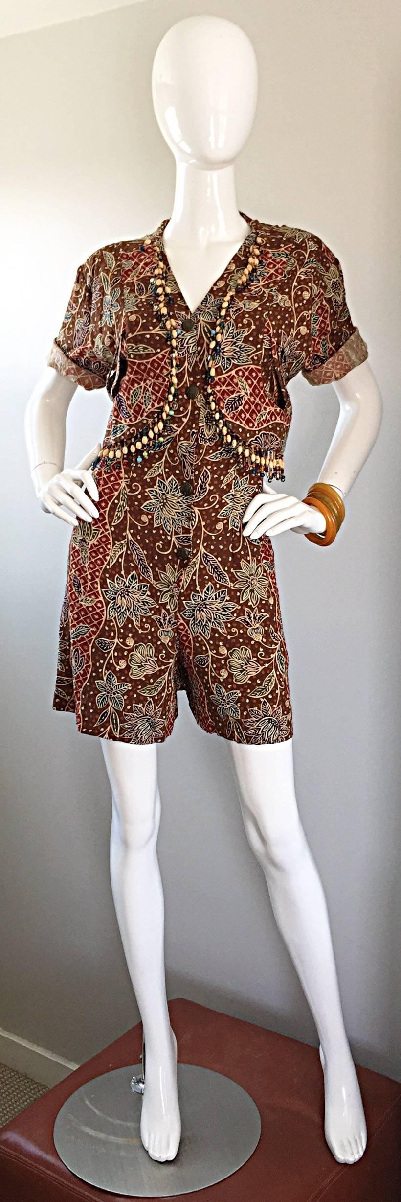 Incredible vintage onesie / romper! Lightweight cotton and rayon blend with tribal ethnic prints throughout. Embellished with hand-sewn beads and bells on the bodice. Attached vest features crochet cut-outs at each side. Hidden zipper up the front