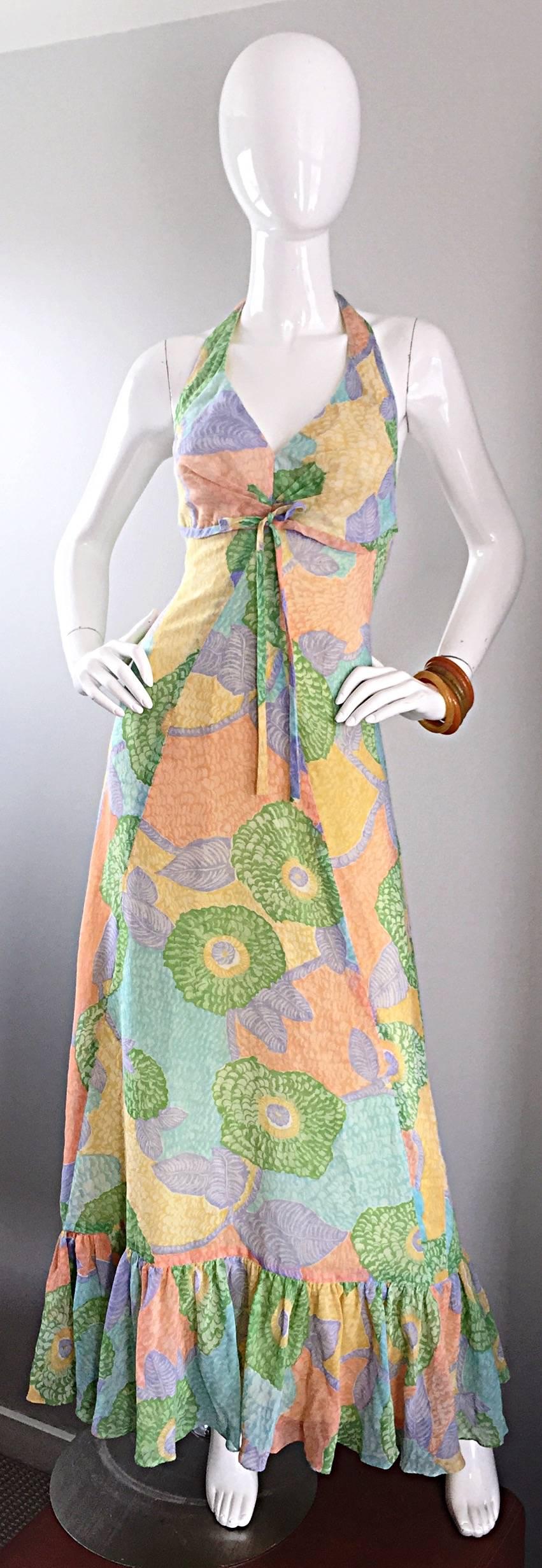 Fantastic 1970s vintage ELLIETTE LEWIS colorful flower printed halter maxi dress! Super soft cotton voile fabric. Everything about this beauty screams chic! Features an attached bow below the bust, and ruffle hem. Buttons at back halter, covered in