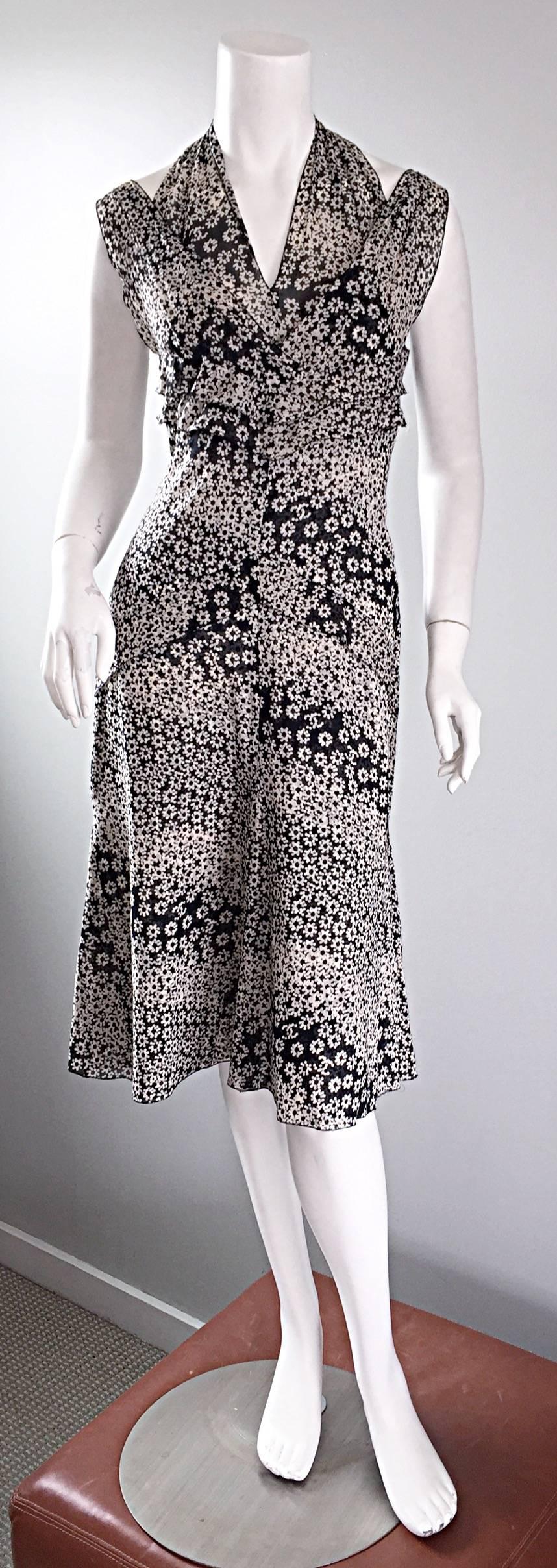Incredible CHANEL dress from the resort 2003 collection! Two layers of lightweight cotton, with black and white printed flowers, and the CC logo intermixed throughout. Features shoulder straps with an attached halter neck that closes with three
