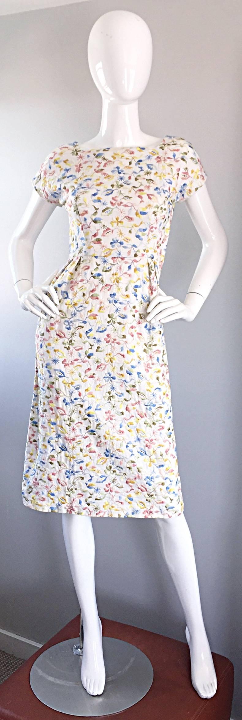 Beautiful vintage late 1950s cotton embroidered day dress! Features completely hand-embroidered pastel flowers in pink, yellow, blue and green throughout the entire dress. Fitted bodice, with a figure hugging skirt, with a slight wiggle fit. Full