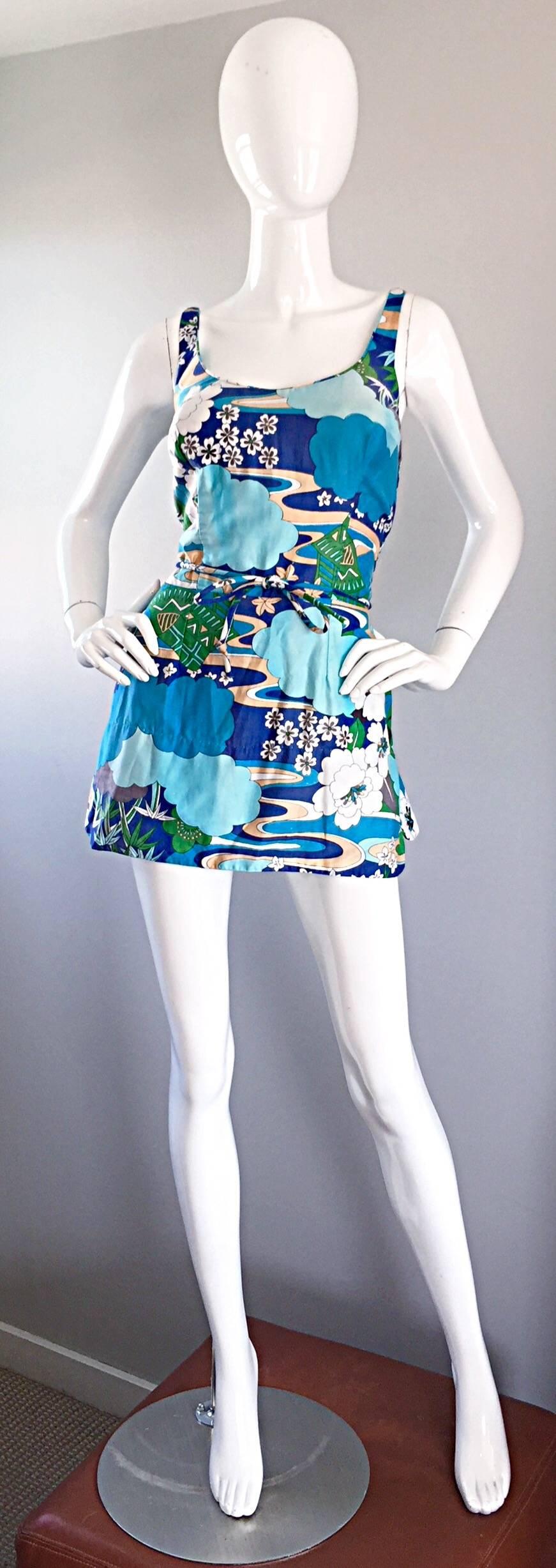 Incredible vintage 60s ROXANNE PERFECTION FIT one piece swimsuit, playsuit, romper, or onesie! Features a Chinese themed print amongst blue and white clouds. Vibrant colors of blues, beige, green and white. Attached bow belt ties in the front.