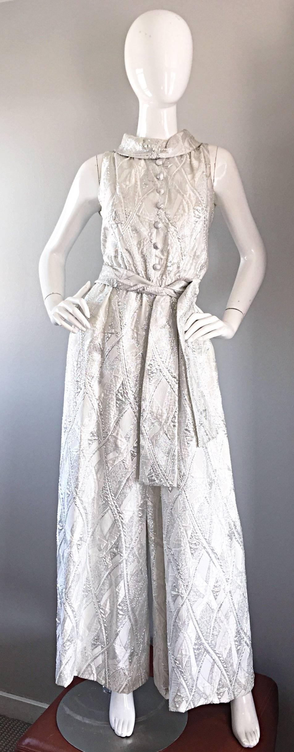 Vintage 60s LESLIE FAY Deadstock (Brand new with original store tags) silver and white metallic silk brocade wide palazzo leg belted jumpsuit! Beautiful soft silk brocade, with matching silk brocade mock buttons up the bodice. Matching detachable