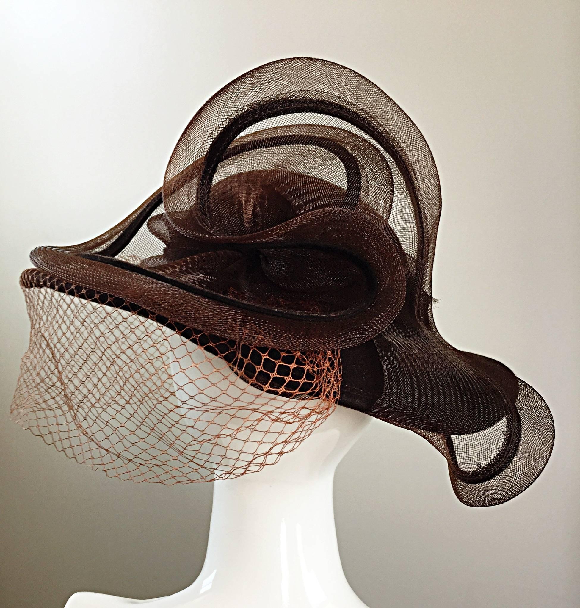Amazing vintage 1980s BOLLMAN HAT COMPANY Brown wool hat! Avant Garde sculptural design, with a brown net that covers one side of the face and side. Large rhinestone encrusted on the lower design. A fantastic statement worthy accessory! In great