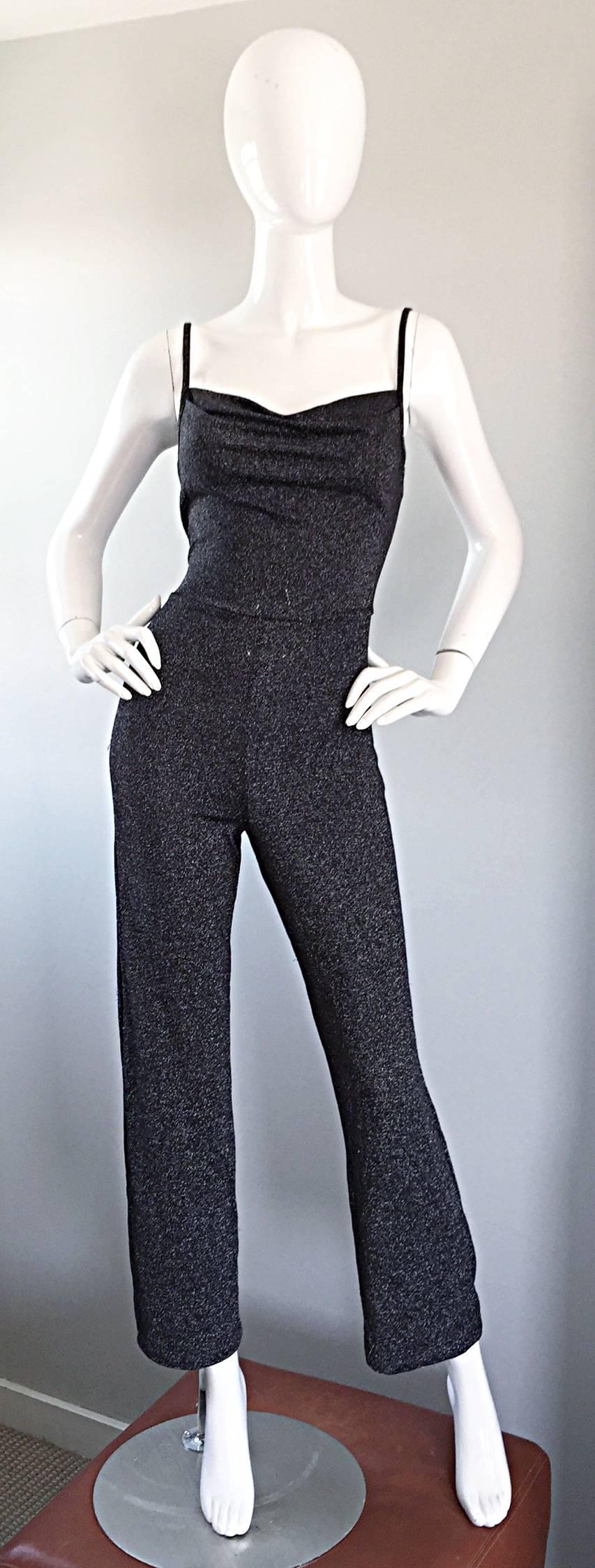Incredible Studio 54 vintage 1970s gunmetal grey metallic jumpsuit! Flattering fitted bodice with draping at the bust. Fitted legs lead to a slightly flared hem. Stretch to fit jersey flatters the body. Hidden zipper up the back. Can be worn belted