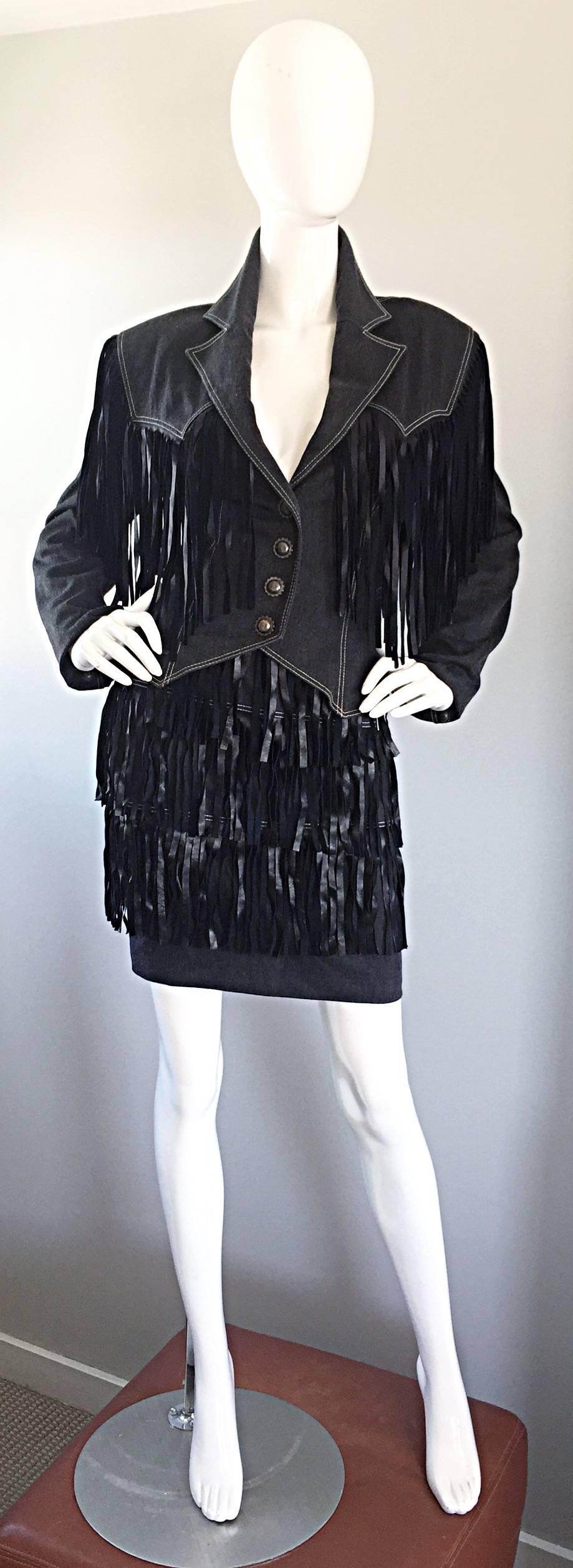 Fantastic and rare vintage PATRICK KELLY denim and leather Western inspired fringed jacket and skirt suit set! Tailored fitted denim jacket with black leather fringe hand-sewn onto the front and back. Perfect high waisted fitted denim skirt, with