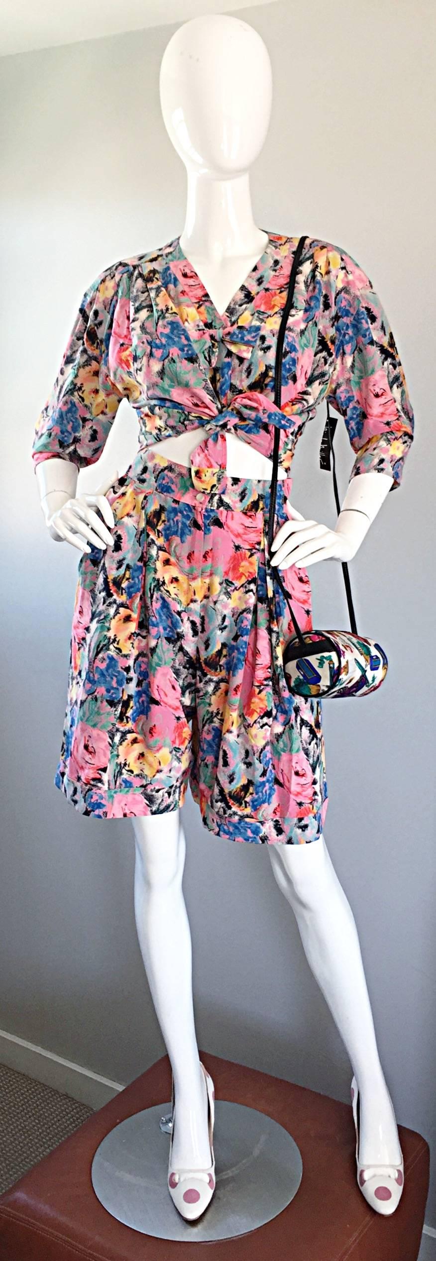Insanely fabulous and chic vintage EMANUEL UNGARO silk top and shorts suit set! Beautiful pastel watercolor print of florals in pink, blue, green, yellow, black, and white throughout. Adorable bow snaps shut above the bust. Buttons up the bodice,