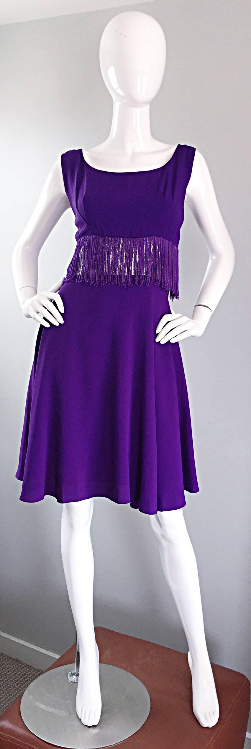 Cutest vintage 1960s purple and silver metallic fringed A - Line dress! Flattering pleats at each bust, with a tailored bodice and full A-Line skirt. Features a silver metallic lurex waistband with purple fringe hand-sewn on top (on the front and